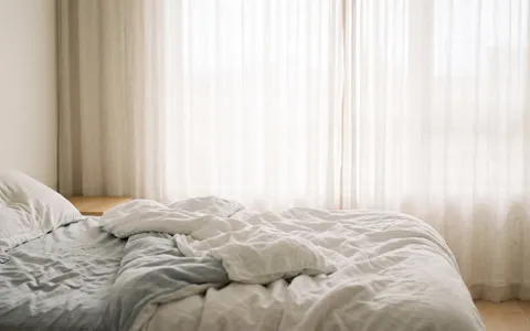 Quarto pela manhã com cama despenteada e vazia